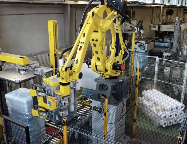 Robot industriale giallo in funzione presso lo stabilimento di Ercopac srl, utilizzato per la movimentazione di rotoli.