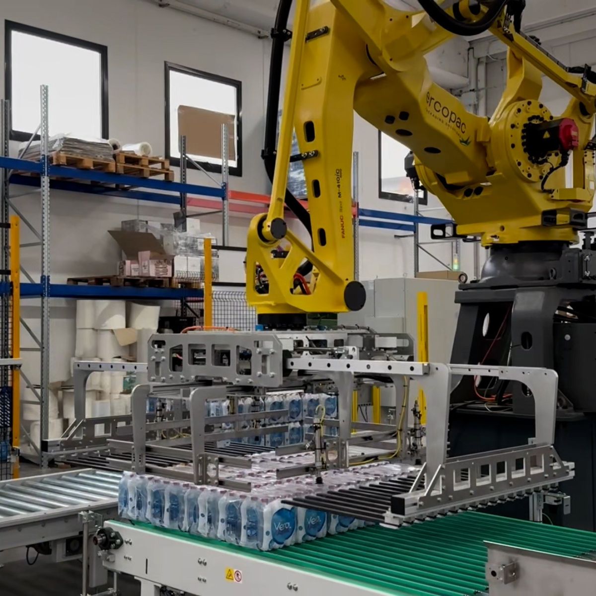 yellow robotic arm handling water bottles