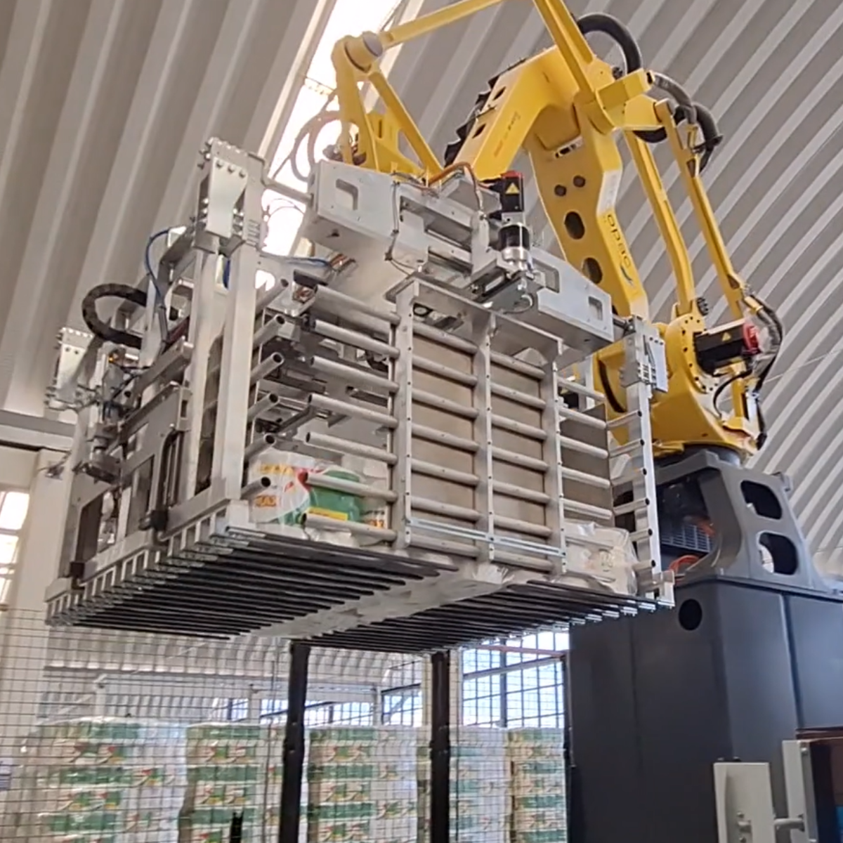 pallettizzatore robotizzato a strato che sposta uno strato di rotoli di carta da un nastro ad un pallet