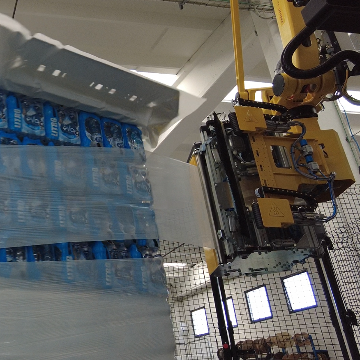 testa di fasciatura che performa il ciclo anti-acqua su un carico pallettizzato fasciando con film estensibile