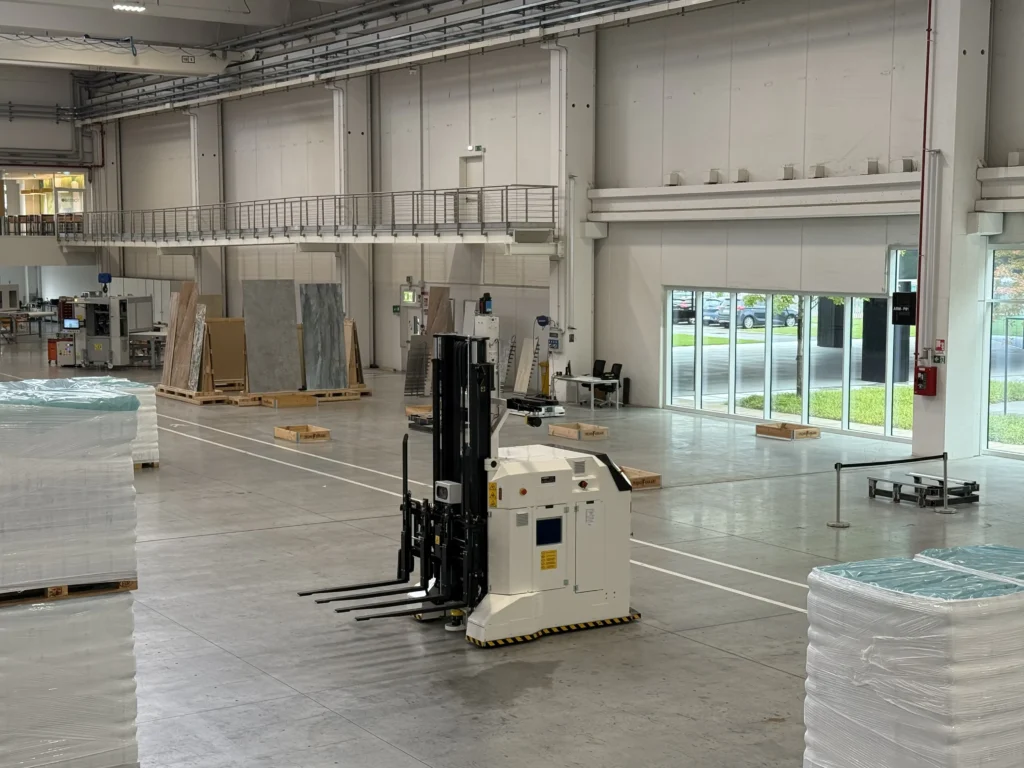 Navetta automatica LGV TecnoFerrari in funzione per la movimentazione interna di pallet in un magazzino industriale